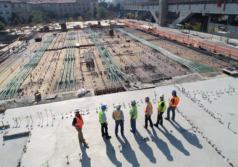 Trabajadores con casco y chaleco reflectante supervisando una faena